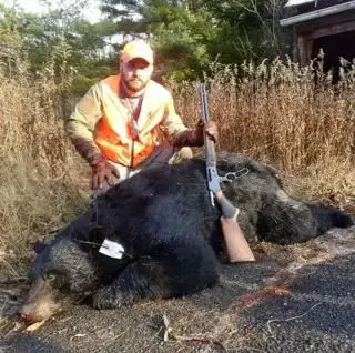 man with bear and rifle